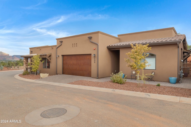 pueblo-style home featuring a mountain view and a garage