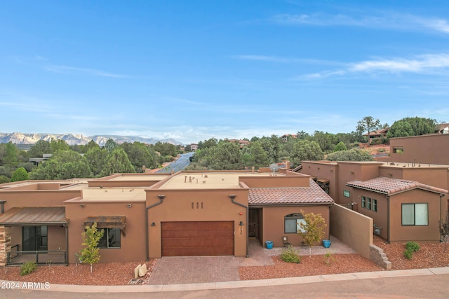 pueblo-style home featuring a mountain view and a garage