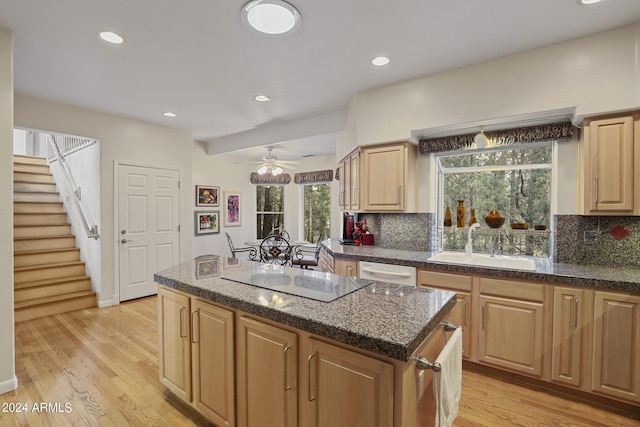 kitchen featuring a kitchen island, electric stovetop, sink, backsplash, and light hardwood / wood-style flooring