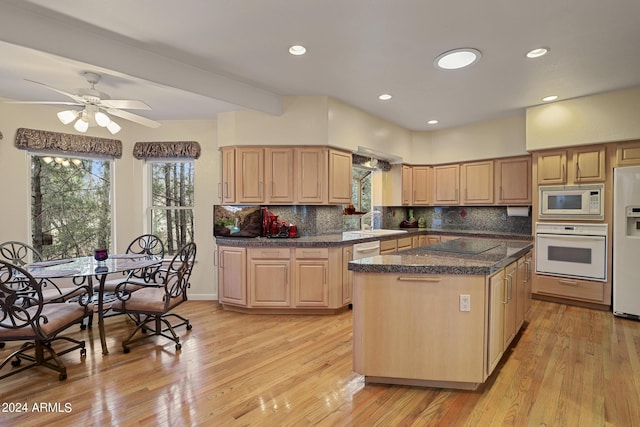 kitchen with sink, white appliances, light hardwood / wood-style flooring, a kitchen island, and decorative backsplash