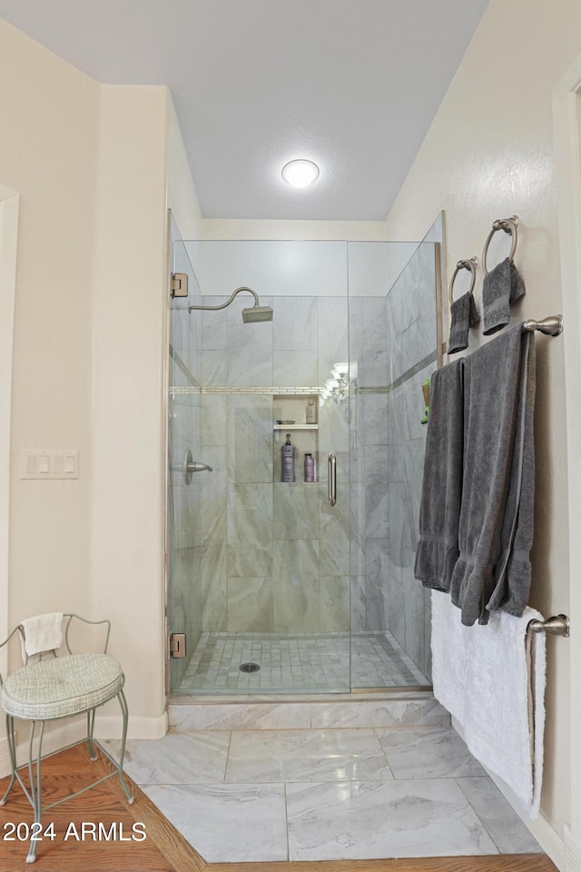 bathroom featuring a shower with door