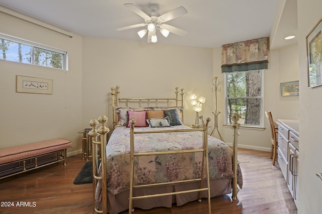 bedroom featuring ceiling fan, wood-type flooring, and multiple windows