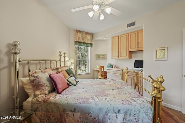 bedroom featuring ceiling fan, dark hardwood / wood-style floors, and built in desk