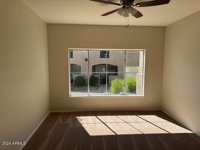 carpeted spare room featuring ceiling fan