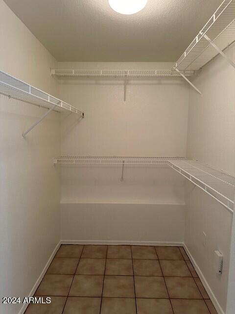 walk in closet featuring dark tile patterned flooring