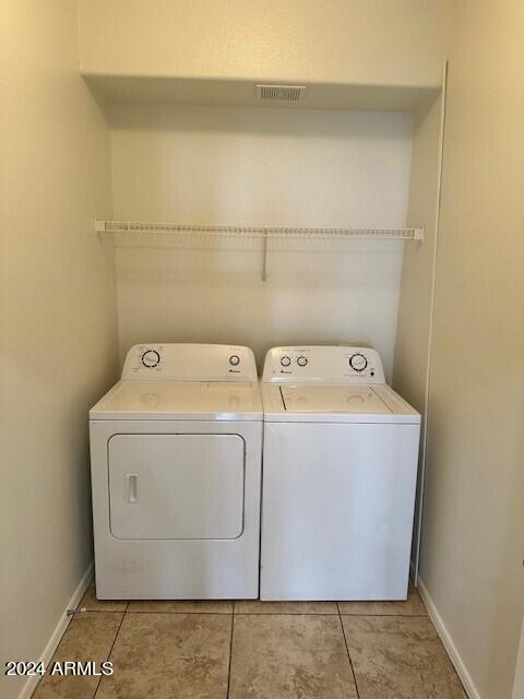 washroom with separate washer and dryer and light tile patterned floors