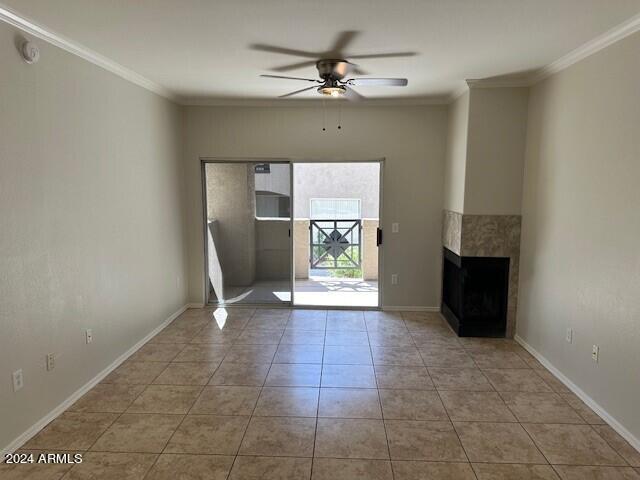 unfurnished living room with crown molding, a multi sided fireplace, light tile patterned floors, and ceiling fan