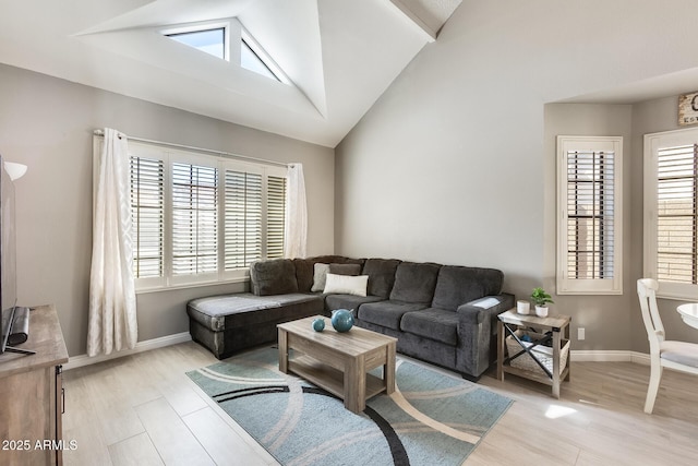 living room featuring light wood-style floors, a healthy amount of sunlight, vaulted ceiling, and baseboards