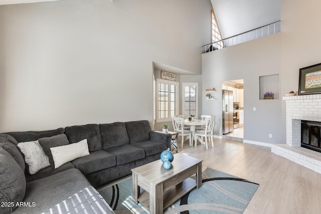 living area with a fireplace, baseboards, and wood finished floors