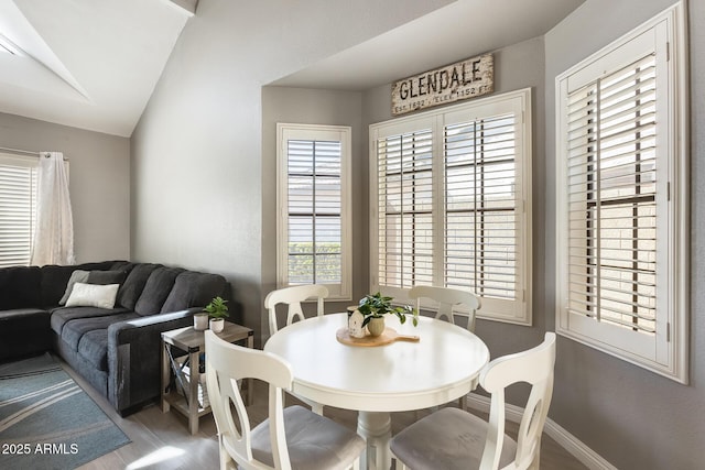 dining room featuring lofted ceiling and baseboards