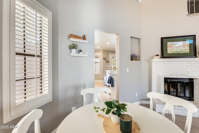 dining area featuring a fireplace, baseboards, and wood finished floors