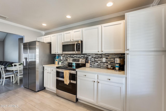 kitchen featuring stainless steel appliances, white cabinets, and visible vents