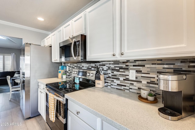 kitchen with tasteful backsplash, white cabinets, light stone countertops, stainless steel appliances, and crown molding