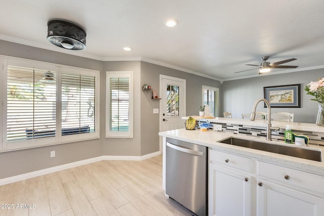 kitchen with light stone counters, crown molding, white cabinets, a sink, and dishwasher