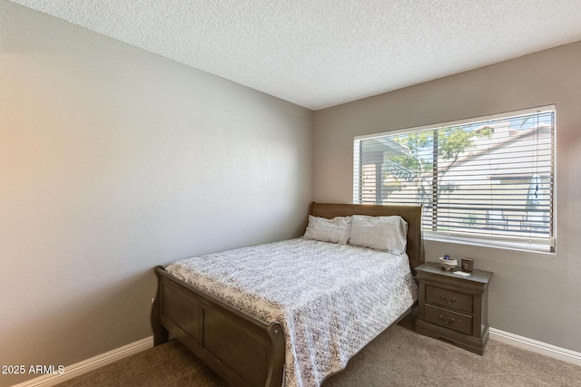 carpeted bedroom with baseboards and a textured ceiling