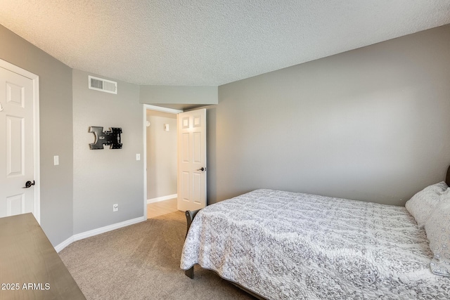 carpeted bedroom featuring visible vents, a textured ceiling, and baseboards