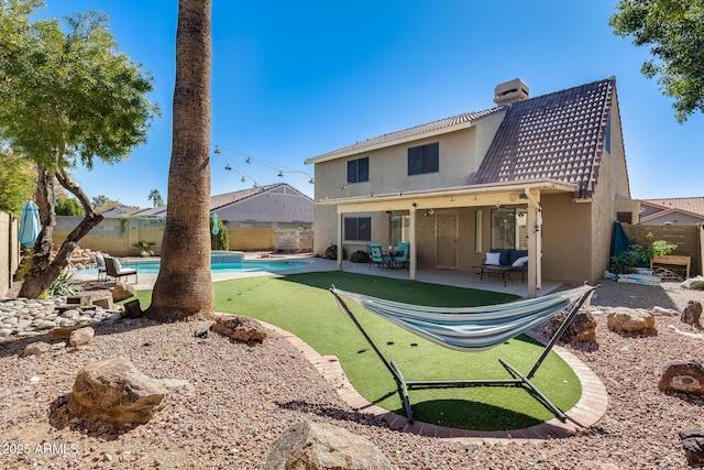 back of property with a fenced backyard, a patio, a chimney, and stucco siding