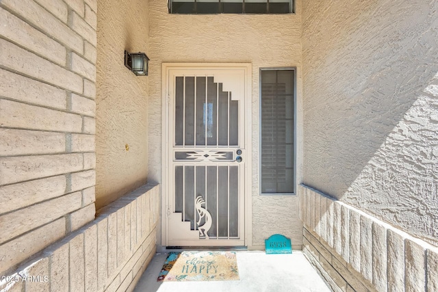 view of exterior entry featuring stucco siding