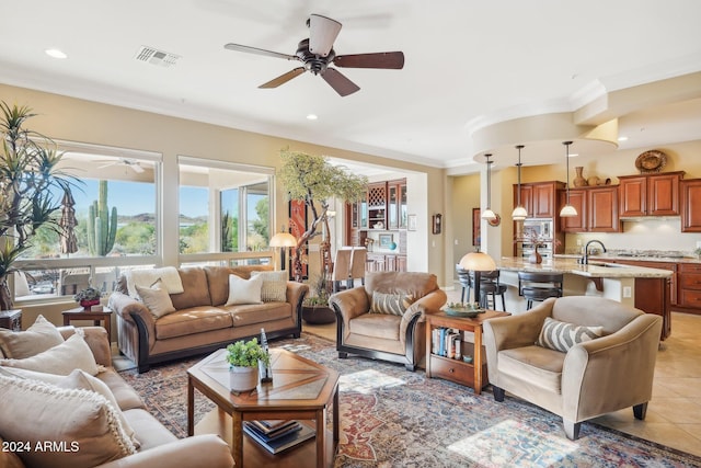 tiled living room with a wealth of natural light, sink, ceiling fan, and ornamental molding