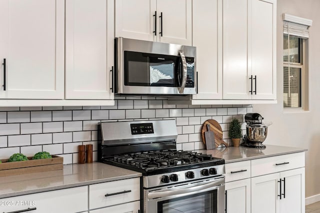 kitchen with decorative backsplash, stainless steel appliances, and white cabinetry