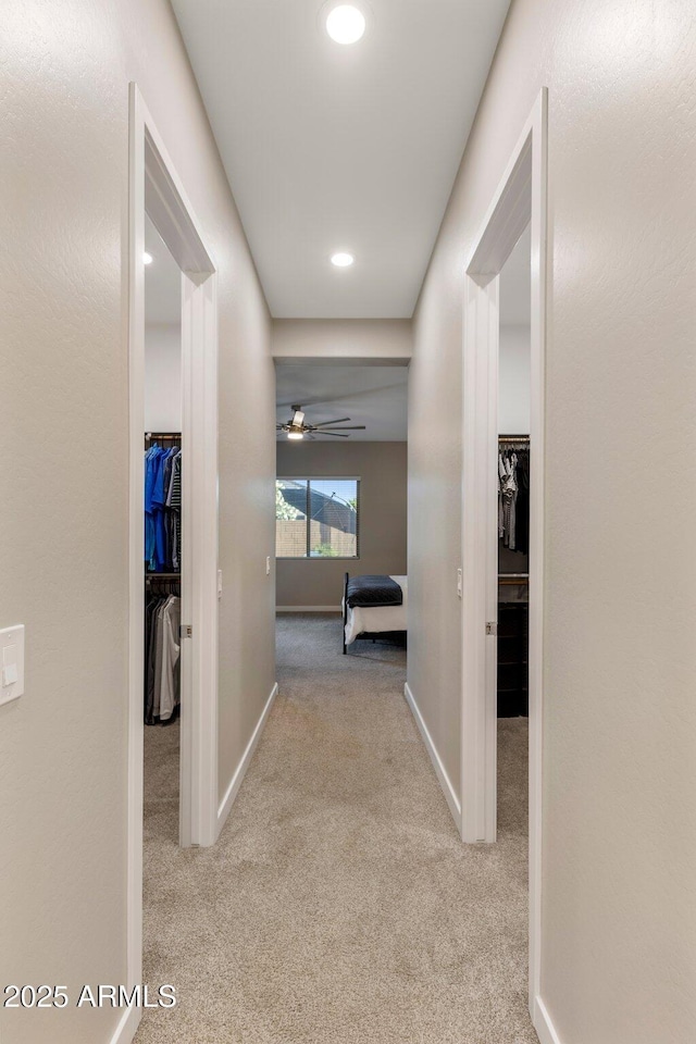 corridor with baseboards, recessed lighting, and carpet