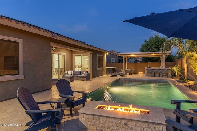 pool at twilight featuring a fenced in pool, an outdoor living space with a fire pit, and a patio area