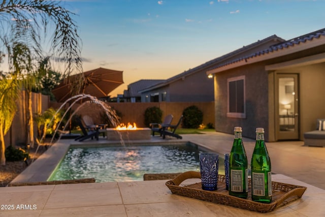 view of pool featuring a fenced backyard, a fenced in pool, a patio, and a fire pit