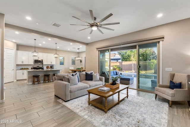 living area with recessed lighting, ceiling fan, visible vents, and wood finish floors
