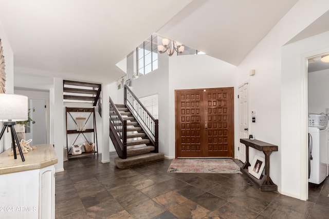 foyer entrance featuring a high ceiling, washer / clothes dryer, and a chandelier