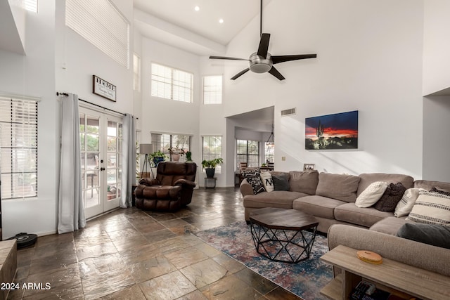 living room featuring ceiling fan, french doors, and a high ceiling