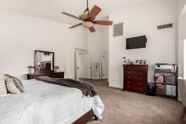 bedroom featuring a towering ceiling, carpet floors, and ceiling fan