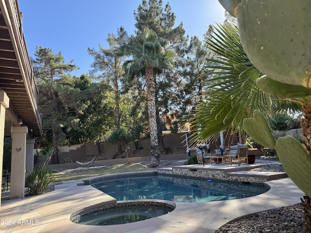 view of swimming pool featuring an in ground hot tub and a patio