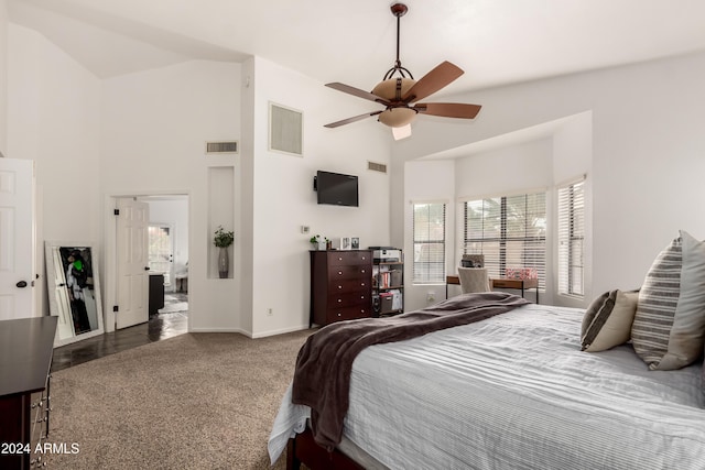 bedroom with dark colored carpet, ceiling fan, and high vaulted ceiling