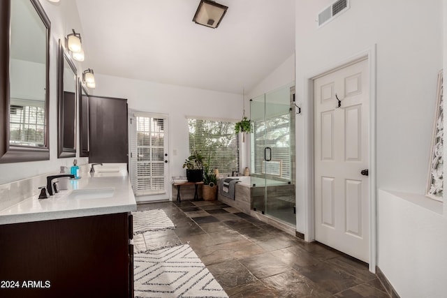 bathroom featuring vanity, a shower with door, and vaulted ceiling