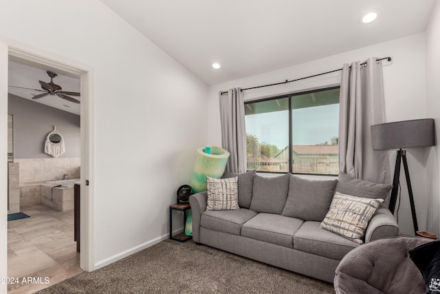 carpeted living room with ceiling fan and lofted ceiling