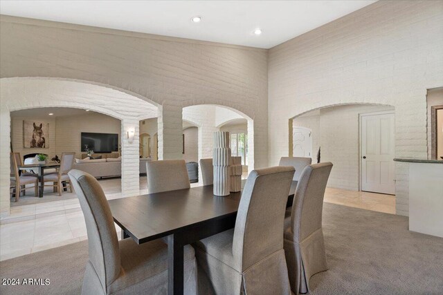 6516 E Maverick Rd, Paradise Valley, AZ 85253 - dining area with light colored carpet, arched walkways, a towering ceiling, and light tile patterned floors