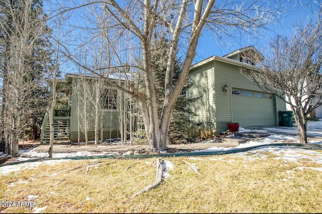 view of front of property with a garage and a front lawn