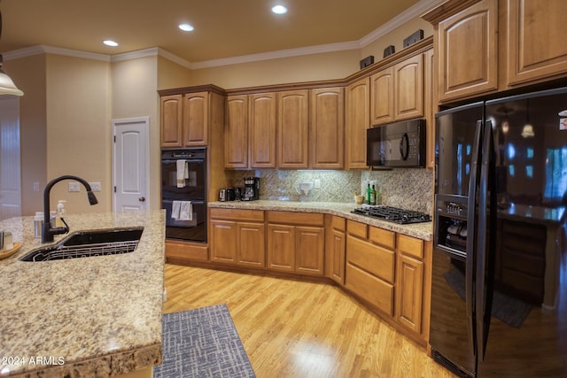 kitchen with black appliances, brown cabinets, and a sink