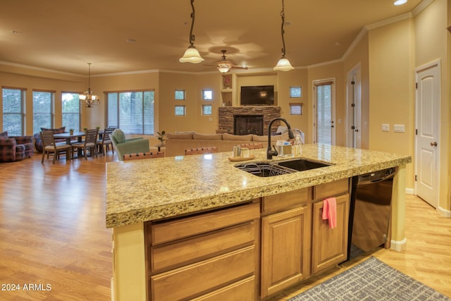 kitchen with a fireplace, a sink, black dishwasher, open floor plan, and light wood-type flooring