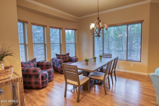 dining room featuring baseboards, ornamental molding, light wood-style flooring, and an inviting chandelier