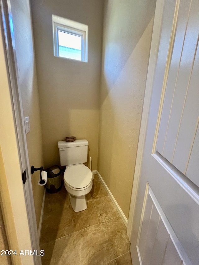 bathroom featuring toilet and baseboards