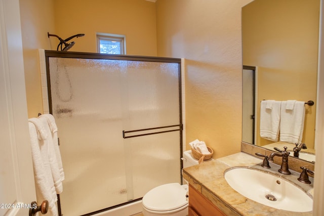 bathroom with a stall shower, vanity, and toilet