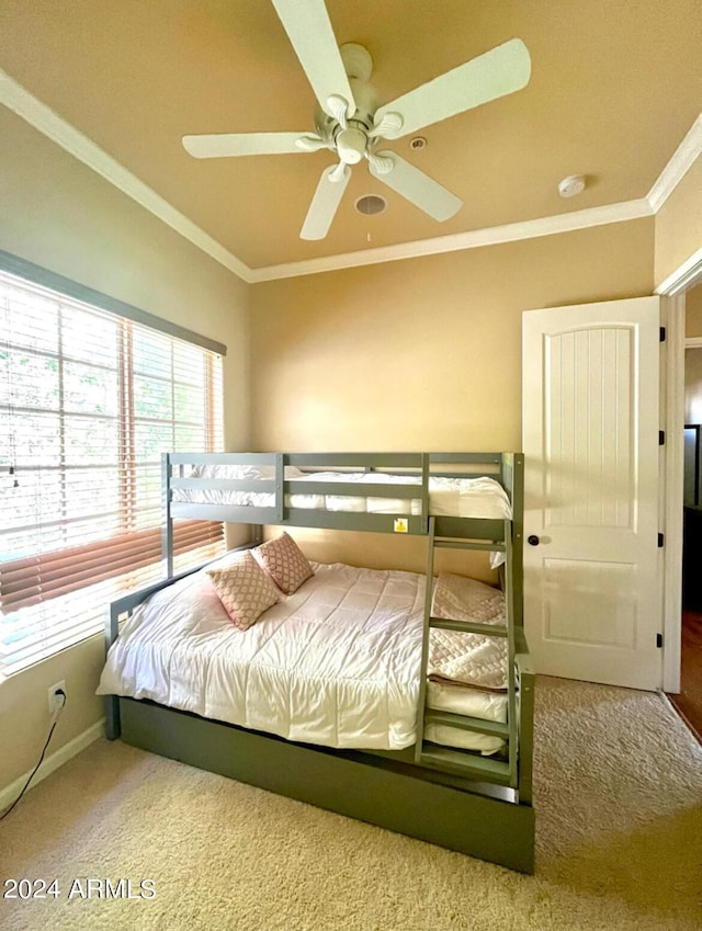 bedroom with ceiling fan, baseboards, carpet flooring, and crown molding