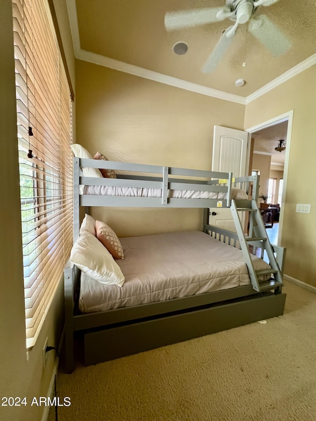 carpeted bedroom featuring baseboards, ceiling fan, and crown molding