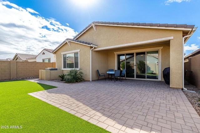 back of house featuring fence, a yard, stucco siding, a tile roof, and a patio area