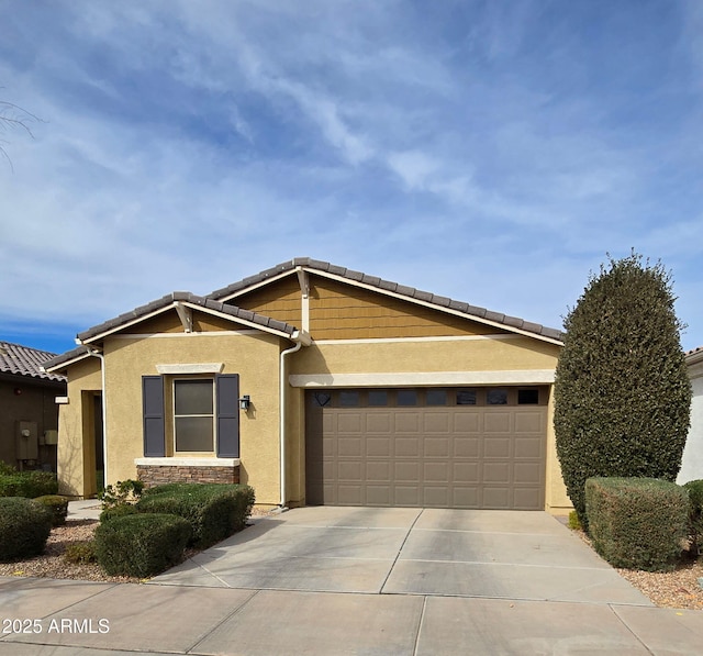 view of front of house with a garage, driveway, and stucco siding