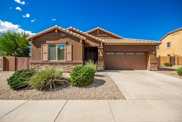 view of front of home featuring an attached garage, stone siding, driveway, and stucco siding