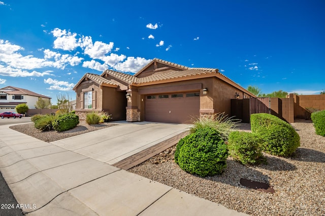 ranch-style home featuring stucco siding, fence, concrete driveway, a garage, and a tiled roof