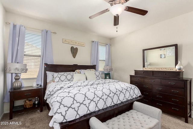 carpeted bedroom featuring multiple windows and ceiling fan