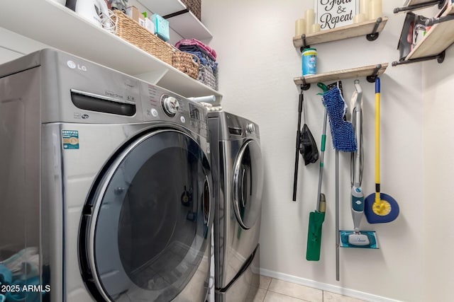 laundry room featuring light tile patterned flooring and washing machine and clothes dryer